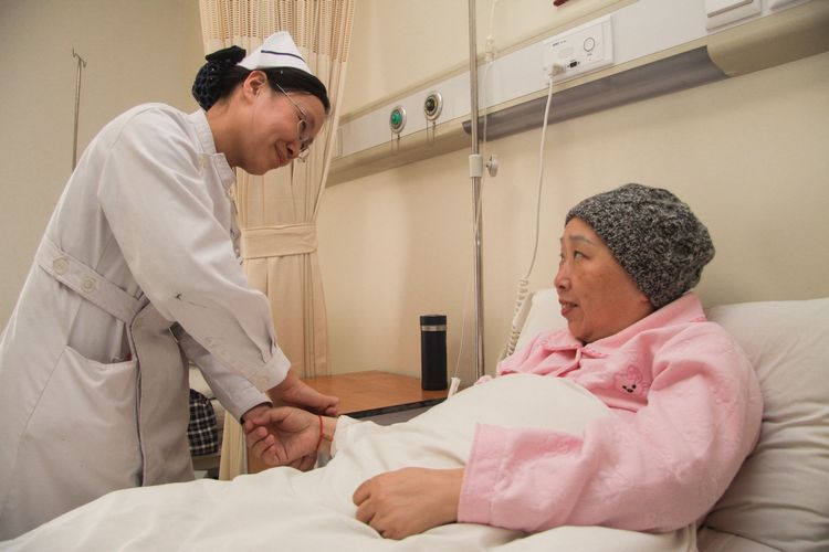 图为三院护士正在为PICC置管患者带上红手链
